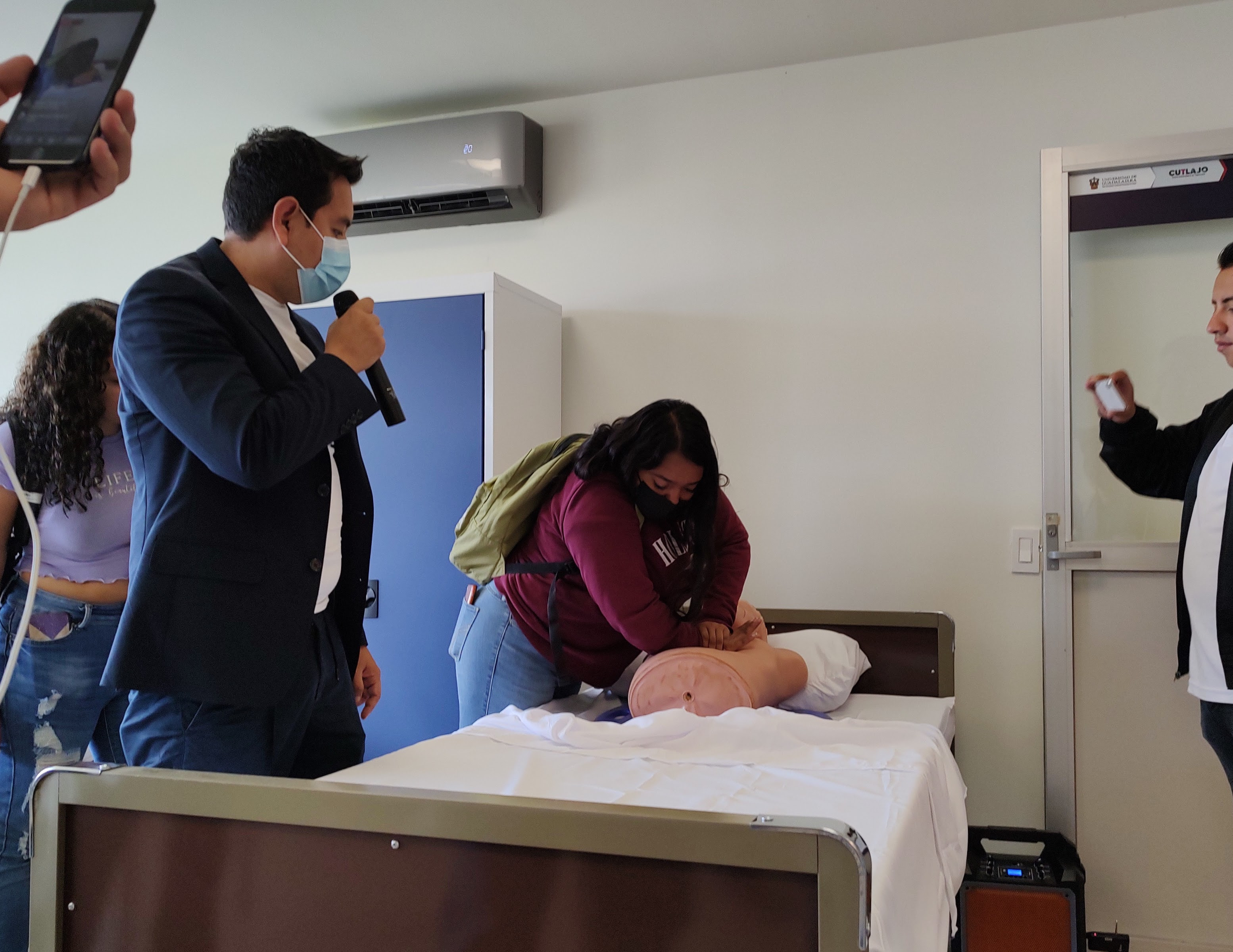 Estudiante practicándo compresiones de pecho en un maniquí.