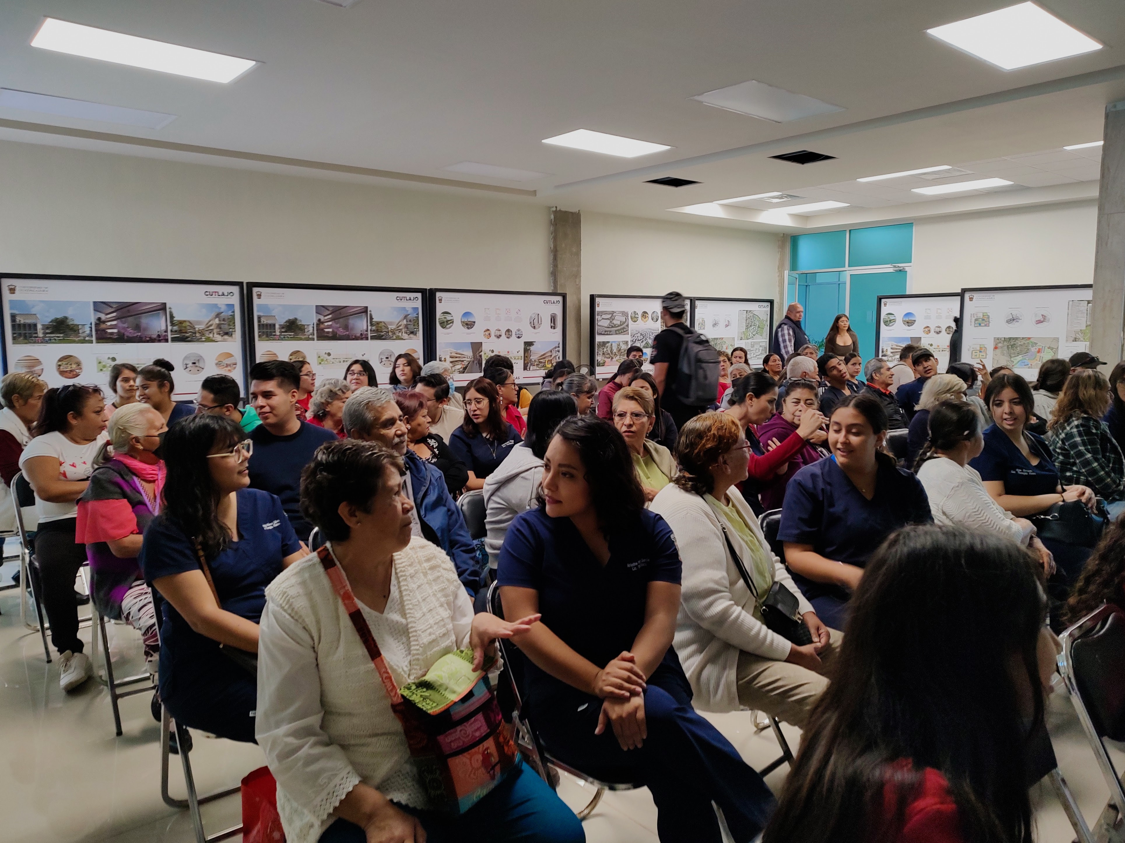 estudiantes y adultos mayores en sala de co-working esperando la pelicula 