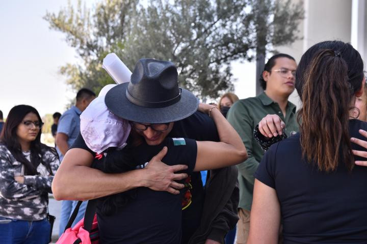 Armenta abrazando a una mujer 