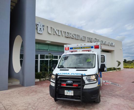 Ambulancia del Hospital Civil de Guadalajara, con la Rectoría del CUTLAJO de fondo 