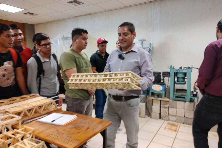 profesor con puente de palitos en sus manos